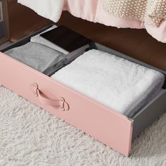 an open pink box with two pairs of socks in it on a white carpeted floor