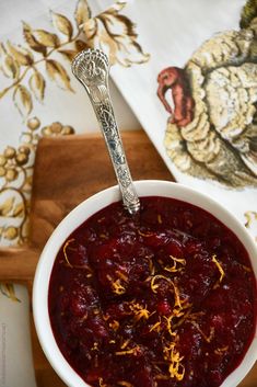 a white bowl filled with cranberry sauce on top of a wooden cutting board