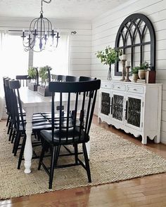 a dining room table with black chairs and white walls