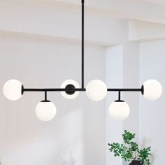 This 6-Light sputnik modern Linear chandelier pendant light is a great blend of modern classic and transitional styles. It's shaped in modern linear and glass globes , featuring matte black finish and white frosted opal glass shades, , which looks low-profile but has the elegant and minimalist aesthetics. The glass sphere hanging light is an eye-catching and focal piece to help complete a timeless interior decor, is ideal for over kitchen island and dining room table, or in a living room and hot Mid Century Modern Dining Table Round, Modern Chandelier Foyer, Modern Black Chandeliers, Modern Linear Chandelier, Signal Hill, Dining Room Pendant, Black Light Fixture, Timeless Interior, Chandelier Metal