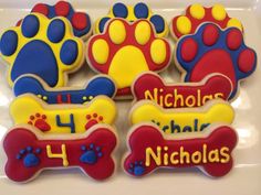 decorated cookies in the shape of dogs paws and bones with name written on each cookie