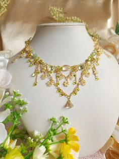 This is a captivating homage to the resplendent canola flowers ('Nanohana') that paint the Japanese landscape in springtime. Embrace the essence of fairy-core charm with this intricately crafted necklace, delicately weaving together hues of gold and green reminiscent of the verdant-gold fields at dawn. 🍃Handcrafted with citrine, prehnite, dyed green freshwater pearls, glass beads, and gold-plated findings. 🍃Measures about 39.5cm (15.5 inches), with 5cm extenders. Transform in to a forest fairy Fairy Core Necklace, Gold Floral Necklace, Fairycore Jewelry, Forest Necklace, Handmade Fairy, Tiered Necklace, Pretty Jewelry Necklaces, Fairy Jewelry, Fairy Wedding