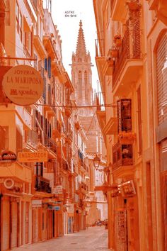 an orange city street with buildings on both sides and a clock tower in the background