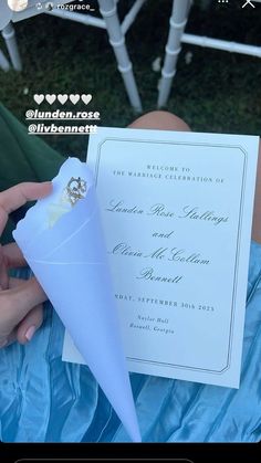 a person is holding a paper cone with a wedding card in front of them on a blue blanket