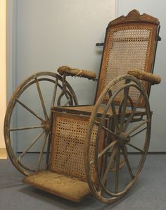 an old wooden wheel chair sitting on the floor