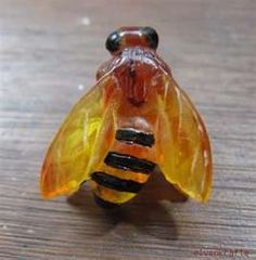 a glass bee figurine sitting on top of a wooden table