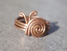 Humble but efective and extraordinary copper wire ring. Like in the pictures made of copper wire diameter 1,2mm. Instead of gemstone there is a little snail made of wire. This little gadget will surely get attention of Your friends on the party or used as an everyday wear. Variety of sizes availabel - please specify the diameter You are intrested in. Opinions about the healthy effects of copper on the human body are quite popular and many of them can be found in the internet. Buying our ring, You receive in addition to potential health properties also a nice piece of exclusive jewelry, which is suitable for everyday wear as well as for special occasions, especially among those who appreciate the uniqueness of handcrafts. Cleaning: This is uncoated copper so it will tarnish. Many people lik Wire Wrapped Jewelry Rings, Handmade Rings Wire, Copper Wire Ring, Copper Wire Crafts, Diy Wire Jewelry Rings, Wire Jewelry Rings, 2024 Ideas, Wire Jewelery, Wire Wrap Jewelry Designs