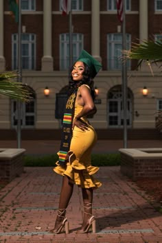 a woman in a yellow dress and green hat posing for the camera with her hands on her hips