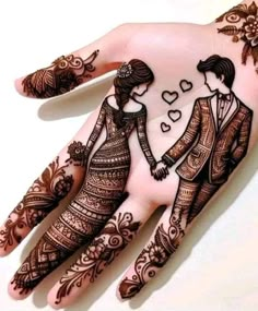 a couple holding hands with henna tattoos on their fingers and arms, all decorated in intricate designs