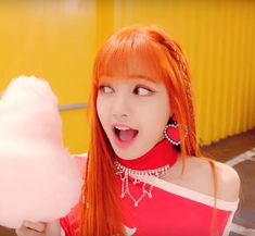 a woman with red hair holding a cotton candy