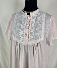 "~ Cute short sleeved Lewis Frimel nightgown in a pretty pale pink ~ Lace details at collar lined with fabric ~ Lace trim at sleeve cuffs ~ Three plastic buttons at chest ~ Made in USA CIRCA: 1980's MATERIALS: No label, probably a cotton/poly blend LABEL: Lewis Frimel CONDITION: Very good - no rips or holes.   MEASUREMENTS:  Vintage sizes are NOT the same as modern sizes.  Please go by the given measurements for a garment and not any listed size when determining fit! ~ No Size tag Shoulder ~ 15.5\" Sleeve ~ 8\" Bust ~ 44\" Length ~ 39\" shoulder to hem At this time I CANNOT ship internationally. I can only ship to US addresses. Excessive shipping charges will be refunded. PLEASE convo me if you have any further questions about this item or would like to see more pictures.  I try to be as a Feminine Short Sleeve Cotton Nightgown, White Short Sleeve Nightgown, Pink Short Sleeve Sleepwear For Spring, Feminine Short Sleeve Nightgown For Home, Spring Nightgown For Pajama Party With Short Sleeves, Spring Short Sleeve Nightgown For Pajama Party, Feminine White Nightgown With Short Sleeves, Feminine Short Sleeve Nightgown For Bedtime, Pink Cotton Nightgown With Lace Trim