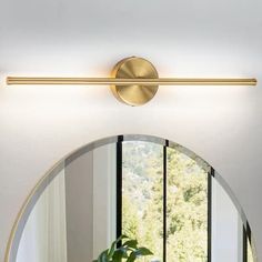 a bathroom mirror sitting above a sink under a light