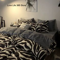 a zebra print comforter on a bed in a room with a love life sign above it