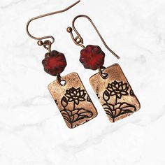 A best seller, these dangle earrings feature a copper charm stamped on both sides and topped with deep red Czech glass flower beads. Handmade and lightweight, they are the perfect go-to red earrings.  Artisan glass beads produced in small quantities in Czech Republic  Hypoallergenic ear wires (nickel and lead free). Choose your ear wire style at checkout. A gift for you or someone special, earrings are carded and in an organza bag. Link back to my shop: https://www.etsy.com/shop/JezaJewelry Flow Red Copper Jewelry Gift, Red Copper Jewelry For Gift, Red Copper Jewelry For Gifts, Red Vintage Copper Jewelry, Vintage Red Copper Jewelry, Red Brass Earrings With Ear Wire, Nickel-free Red Brass Earrings, Vintage Red Copper Earrings, Red Copper Earrings