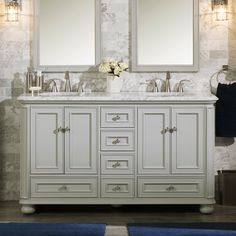 a bathroom vanity with two mirrors above it and blue rugs on the floor below