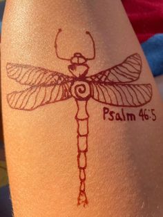 a woman's leg with a tattoo on it that has a dragonfly drawn on it