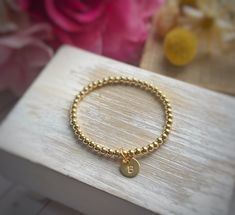 This personalized bracelet is simple, dainty, and makes the perfect gift! The bracelet is made with 4mm gold-filled beads and a 3/8" petite charm (also gold-filled) stamped with the initial of your choice. Add as many charms as you would like! Nickel Free 14k Gold-filled Bracelet, Nickel-free 14k Gold-filled Gold Bracelet, Handmade Gold Bracelet In 14k Gold Filled, Dainty Gold Charm Bracelet Nickel-free, Handmade Gold Bangle Charm Bracelet, Handmade Dainty Gold Charm Bracelet, Gold Dainty Handmade Charm Bracelet, Dainty Handmade Gold Charm Bracelet, Adjustable Gold Beaded Bracelets As Gift