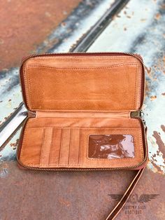 This Rosa Wallet is made with a soft Saddle Brown leather and has a zip closure. It is light weight and is an instant classic that can go with a wide range of purses designs. + Exterior: Soft saddle brown leather + Zipper closure + Removable wrist strap + Leather interior features: 1 clear ID slot, 4 card slots, 1 slip pocket and 1 cash compartment + Measures: 8" W x 4" H x .5" D + Made by STS Ranchwear Saddle Brown, Leather Zipper, Leather Interior, Wrist Strap, Saddle, Card Slots, Slots, Leather Straps, Brown Leather