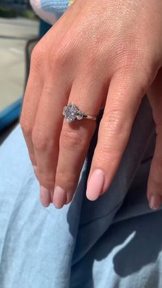 a close up of a person's hand with a diamond ring on their finger