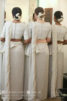 three women standing in front of a mirror with their backs turned to the same direction