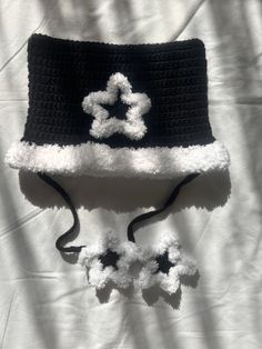 a black and white crocheted hat with pom - poms on it