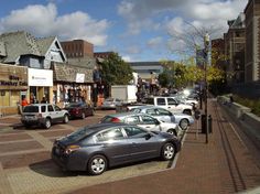 cars are parked on the street in front of shops