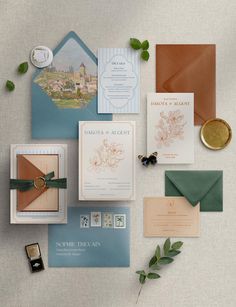 the wedding stationery is laid out on top of each other, including envelopes and cards