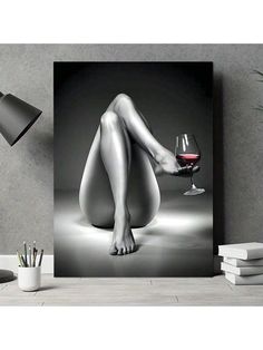 a black and white photo of a woman's legs with a glass of wine