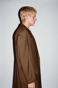 A pared-down sartorial classic with an irreverent twist. This statement structural coat is tailored to perfection with sharp, broad shoulders and clean lines. Constructed in a supremely soft & fluid 100% lightweight wool that drapes below the knee, this layer offers a dose of sophistication to transitional dressing. Classic Structured Single-breasted Outerwear, Classic Outerwear With Concealed Front And Suit Collar, Classic Outerwear With Structured Fit And Lapel Collar, Classic Structured Outerwear With Lapel Collar, Classic Structured Outerwear With Concealed Placket, Classic Structured Solid Outerwear, Classic Structured Outerwear For Business Casual, Structured Classic Outerwear For Business Casual, Elegant Oversized Wool Blazer