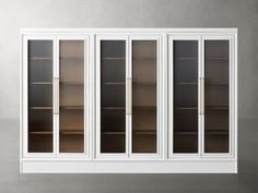 a white bookcase with glass doors on the front and bottom, against a gray wall