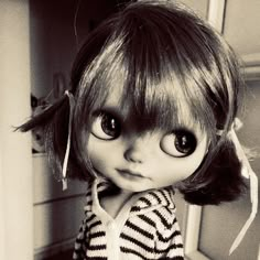 a black and white photo of a doll with big eyes