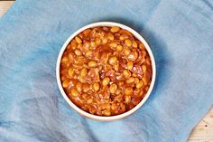 a white bowl filled with beans on top of a blue cloth