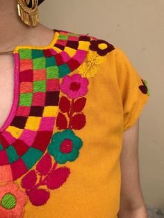 "Pretty Mexican top. Hand-embroidered with colourful flowers. Made with Muslin-soft and comfortable. Fits size Small Measurements taken flat: Armpit to armpit 21\" Bottm hem width 21 1/2\" Shoulder to bottom hem 27\"" Yellow Bohemian Tops For Festivals, Yellow Bohemian Festival Blouse, Bohemian Yellow Blouse For Festival, Yellow Bohemian Blouse For Festival, Yellow Floral Embroidery Blouse For Vacation, Fiesta Tops With Floral Embroidery, Folk Style Multicolor Tops For Cinco De Mayo, Multicolor Folk Tops For Cinco De Mayo, Multicolor Tops For Cinco De Mayo Festival