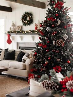 a decorated christmas tree in a living room with red and silver ornaments on the top