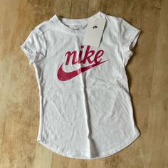 Nwt Nike The Nike Tee Shortleeve White Crewneck With Nike Pink Graphic On Front, Size 6x (6-7 Years Old), Cotton T-Shirt, Sold As Pictured No Known Flaws Or Imperfections. *Non-Smoking Pet Free Home Pink Long Sleeve Nike Tops, Feature Nike Tee, Sporty Pink Nike T-shirt, Affordable Playful Nike T-shirt, Cheap Playful Nike T-shirt, Nike Tee, Dri Fit Shirt, White Crewneck, Nike Tees