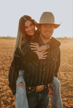 a man holding a woman on his back in an open field