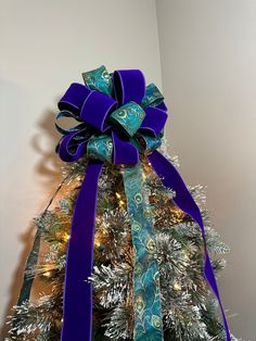 a decorated christmas tree with blue and green ribbons