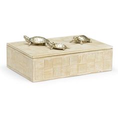 a wooden box with three brass turtles on the lid and two smaller ones sitting on top