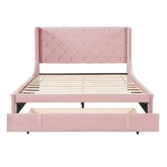 a pink bed frame with two drawers underneath it and the headboard is upholstered