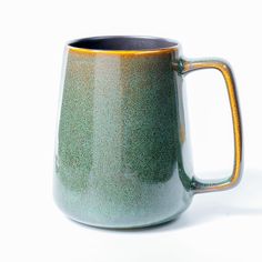 a green and yellow mug sitting on top of a white table