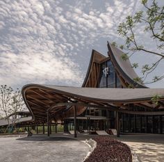 a large building with a curved roof on the top and side of it's entrance