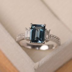 This ring features a 7*9mm emerald cut London blue topaz and sterling silver finished with rhodium. Customization is available. It is made by hand, and it will take about 7 days to finish the ring after your payment is completed. Main stone: London blue topaz Main stone weight: Approx 3.3 ct Metal type: sterling silver finished with rhodium Accent stone: cz Customization is available, I also can make it with 14k solid gold (white or yellow or rose) and diamond accent stone, just feel free to con Elegant Topaz Rings With Rectangular Stone, Elegant Baguette Cut Topaz Promise Ring, Elegant Emerald Cut Topaz Ring With Center Stone, Sterling Silver Emerald-cut Topaz Promise Ring, Sterling Silver Topaz Promise Ring, Emerald Cut, Classic Emerald-cut Topaz Ring In Sterling Silver, Emerald Cut Sapphire Ring With Baguette Diamonds, Emerald Cut Sterling Silver Topaz Promise Ring, Rectangular Topaz Ring With Prong Setting For Wedding