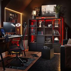 a room with a desk, chair and bookcase in the corner is lit up by red lights