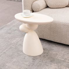 a white coffee table sitting on top of a carpeted floor next to a couch