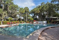 an empty swimming pool surrounded by palm trees