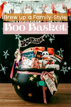 a bowl filled with halloween treats and candy on top of a wooden table next to a chalkboard