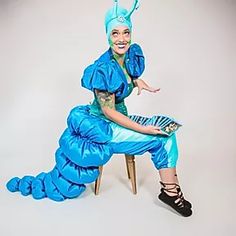 a woman dressed in blue sitting on a chair