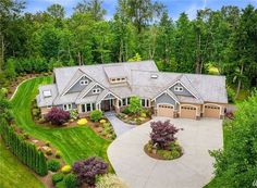 an aerial view of a large home surrounded by trees and shrubs in the middle of a wooded area