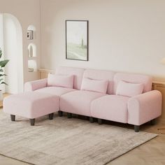 a pink couch sitting on top of a rug in a living room