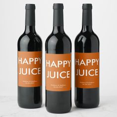 three bottles of happy juice on a marble countertop with the words happy juice printed on them